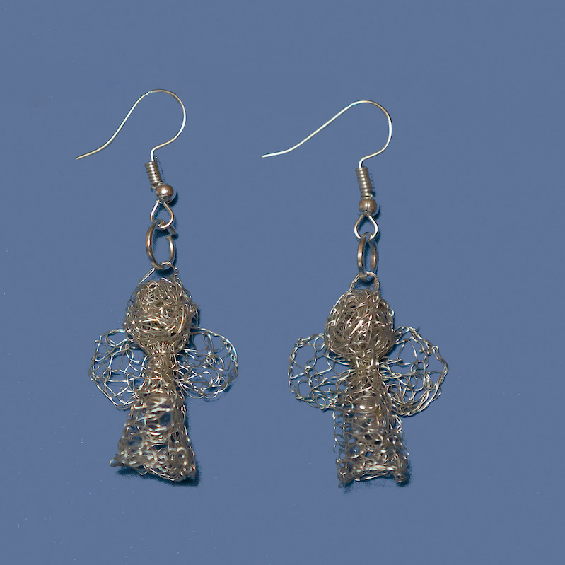 Tiny and delicate Karoo Angels Juweel Earrings. Made of knit silver coloured coated copper wire adorned with a small preciosia crystal bead shining out from within the bodice of the angel 