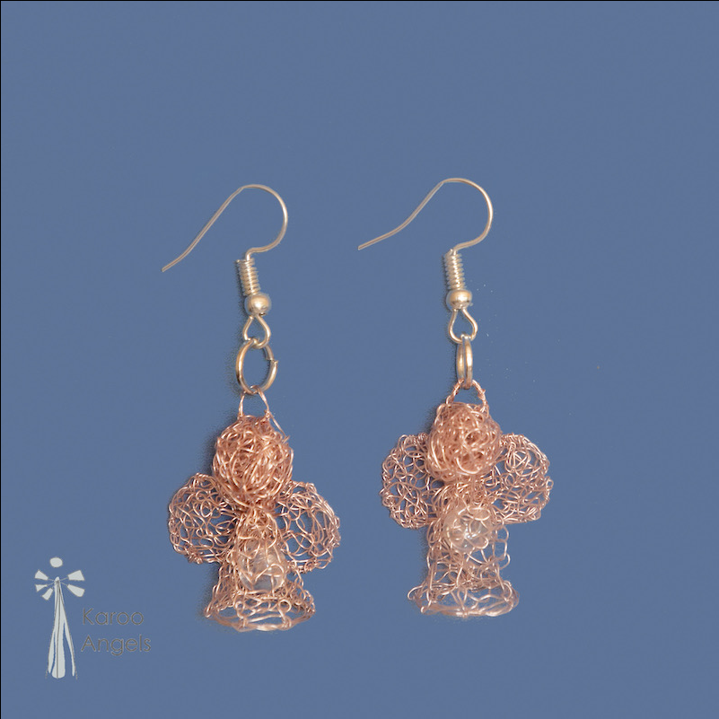 Tiny and delicate Karoo Angels Juweel Earrings. Made of knit rose gold coloured coated copper wire adorned with a small preciosia crystal bead shining out from within the bodice of the angel 
