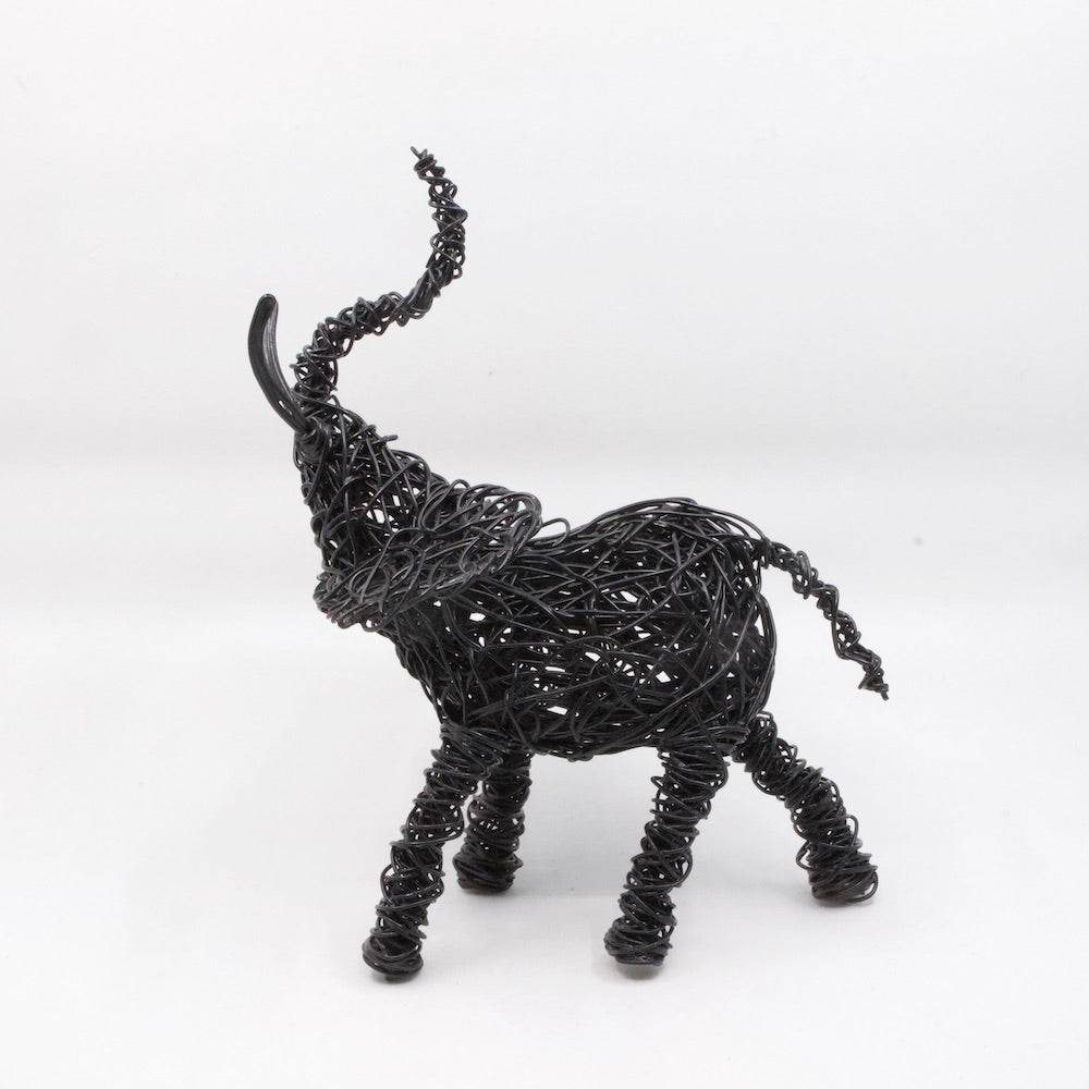 side view of hand twisted galvanized wire art elephant in powder coated black with trunk up