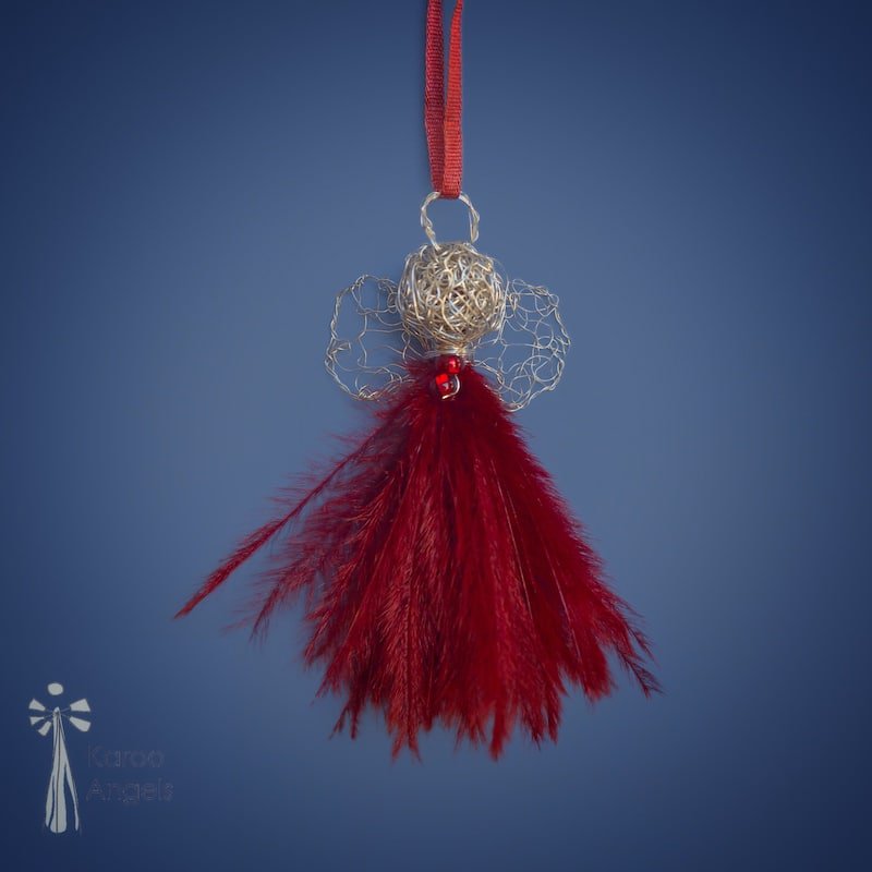 Tiny and delicate Karoo Angels Juweel Angel Pendant. Made of crocheted silver coloured coated copper wire adorned with a small preciosia crystal bead and scarlet red ostrich feathers. It hangs off a silk tie matching the colour of the wire.  Size 3.5cm