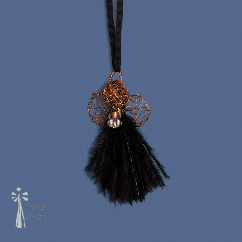 Tiny and delicate Karoo Angels Juweel Angel Pendant. Made of crocheted amber coloured coated copper wire adorned with a small preciosia crystal bead and black ostrich feathers. It hangs off a silk tie matching the colour of the wire.  Size 3.5cm