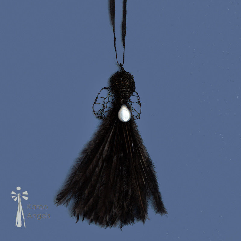 Tiny and delicate Karoo Angels Juweel Angel Pendant. Made of crocheted ink black coloured coated copper wire adorned with a small preciosia crystal bead and black ostrich feathers. It hangs off a silk tie matching the colour of the wire.  Size 3.5cm