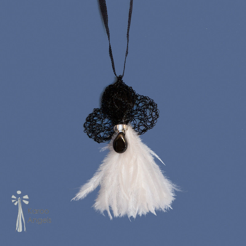 Tiny and delicate Karoo Angels Juweel Angel Pendant. Made of crocheted ink black coloured coated copper wire adorned with a small preciosia crystal bead and white ostrich feathers. It hangs off a silk tie matching the colour of the wire.  Size 3.5cm