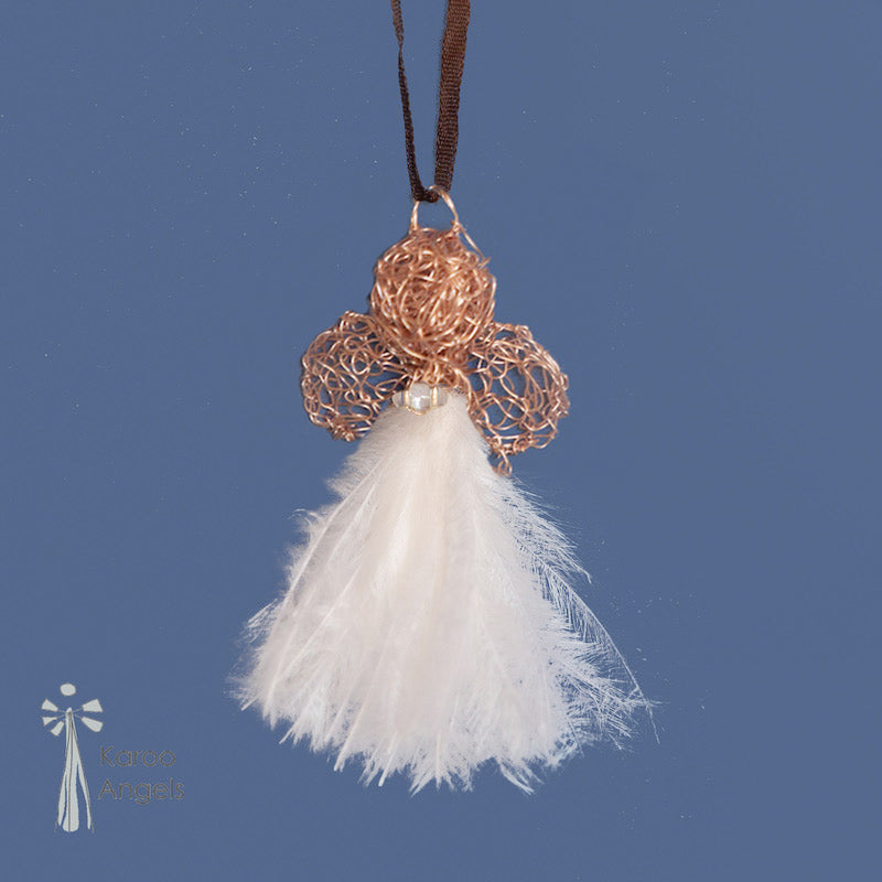 Tiny and delicate Karoo Angels Juweel Angel Pendant. Made of crocheted rose gold coloured coated copper wire adorned with a small preciosia crystal bead and white ostrich feathers. It hangs off a silk tie matching the colour of the wire.  Size 3.5cm