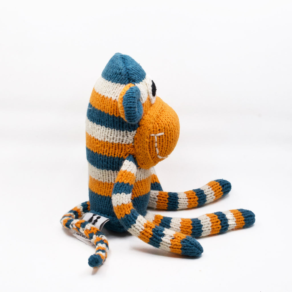 side view of knit snuggle monkey in orange blue and white stripes