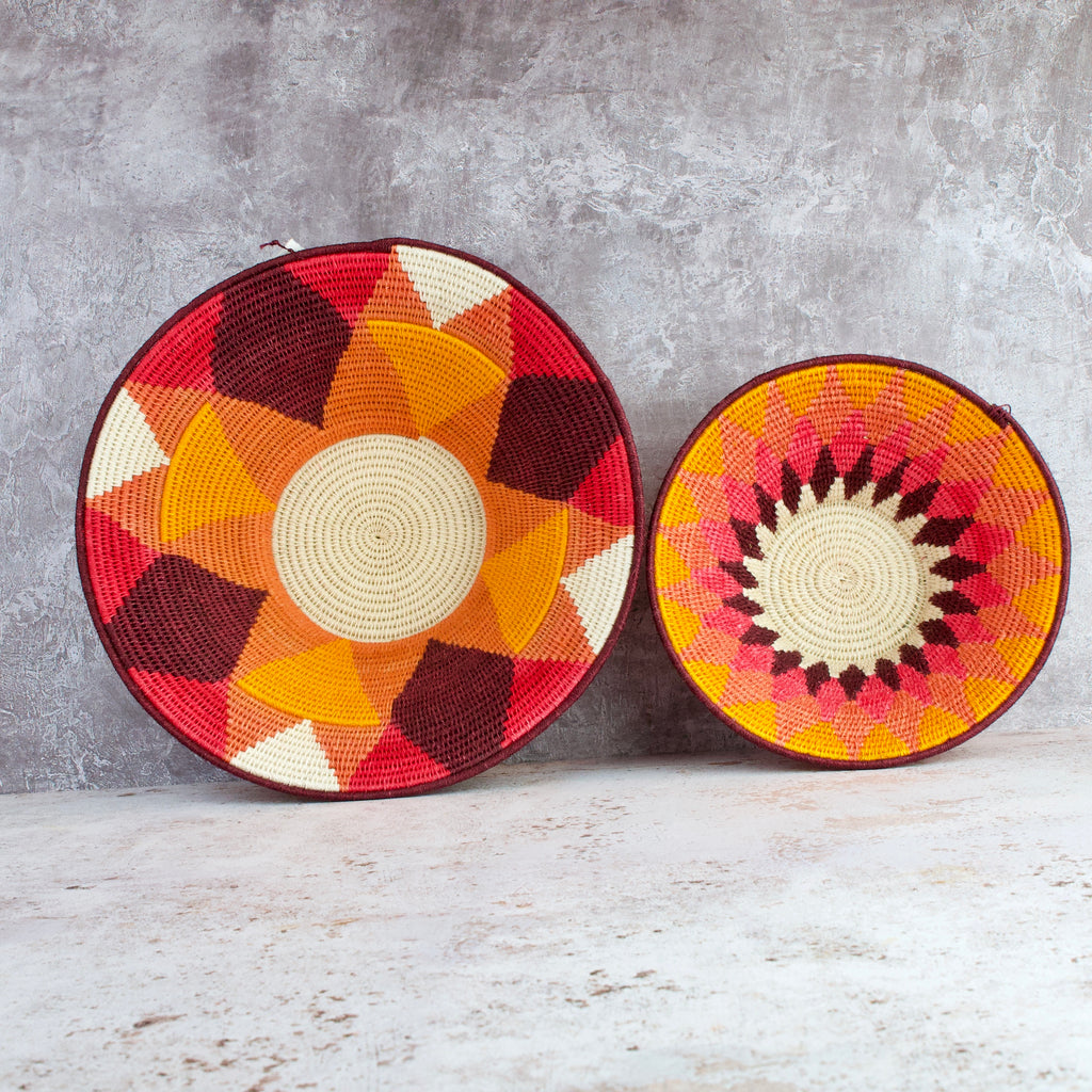 inside of medium and small hand woven sisal baskets side by side. Sundial pattern medium and diamond pattern small. summer of love mixed colours of cream, mango,coral, fuscia, aubergine