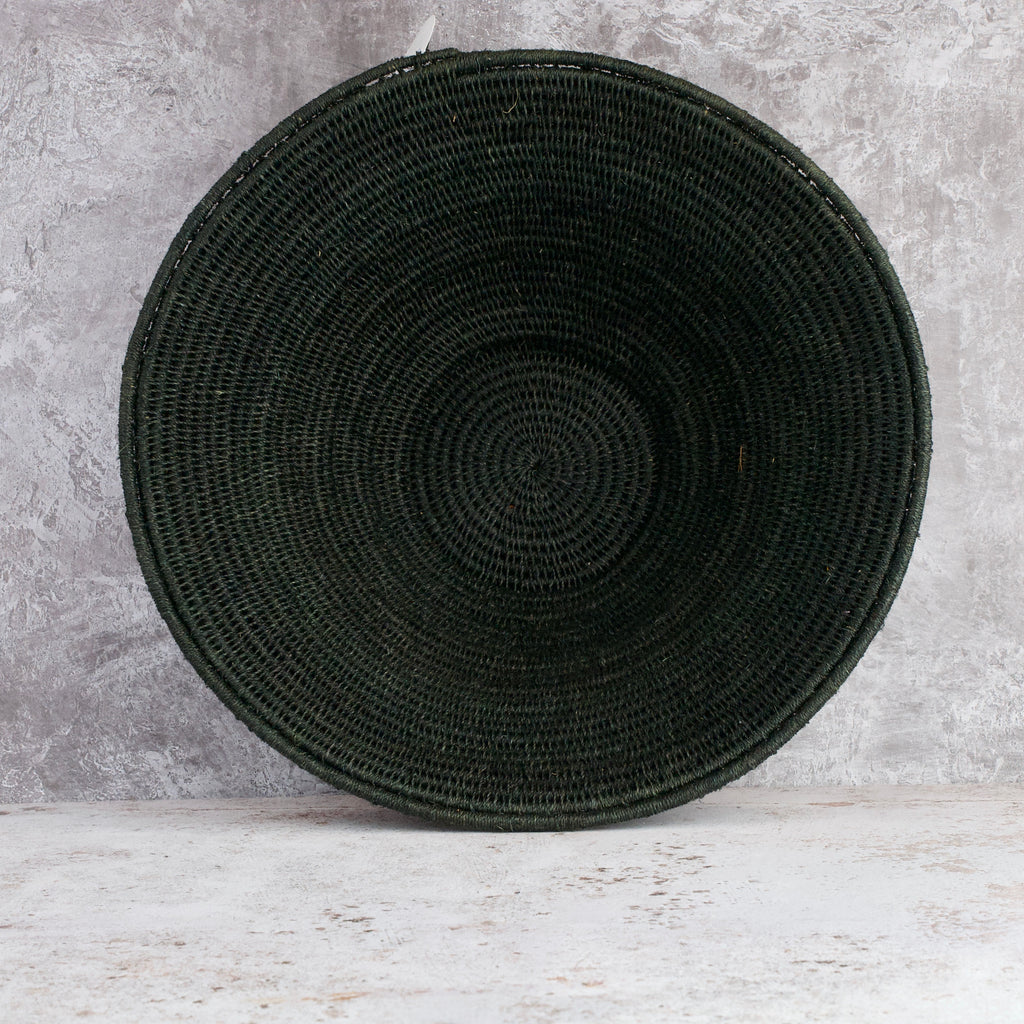 large hand woven sisal basket in black standing on end showing inside of basket