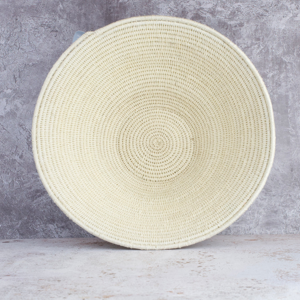 cream coloured hand woven sisal basket standing on end showing inside of basket