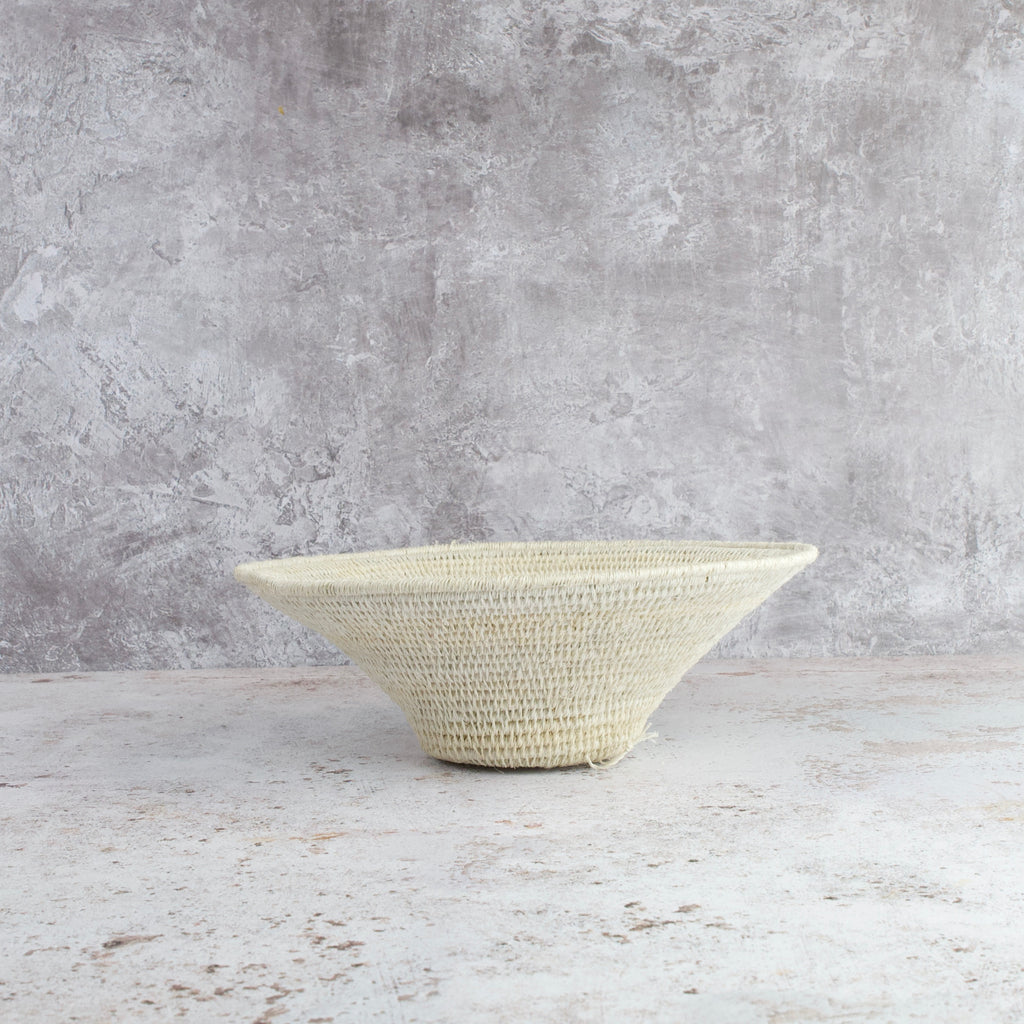 side view of medium size hand woven sisal basket in cream