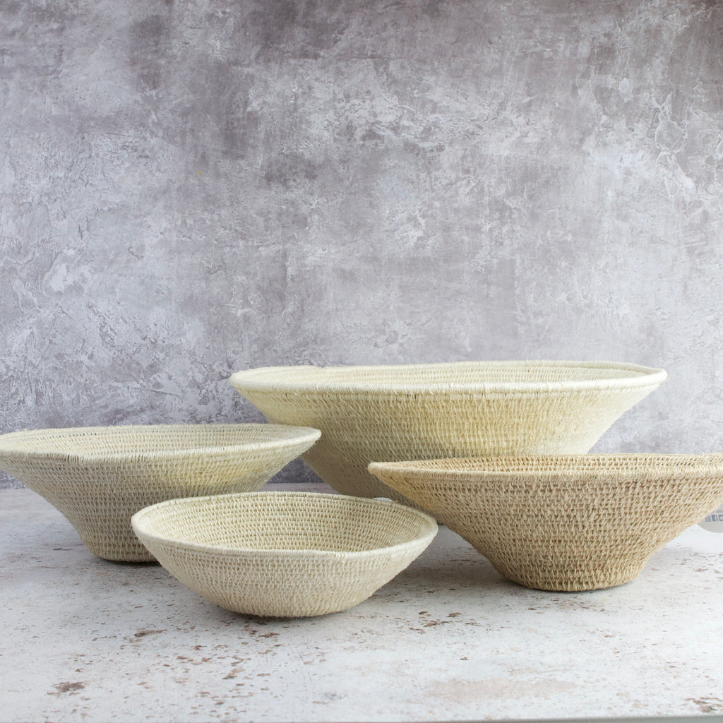 grouping of four hand woven sisal baskets in natural colour and various sizes